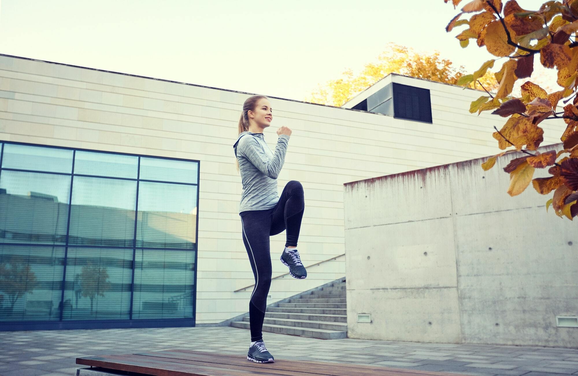 happy woman exercising on bench outdoors
