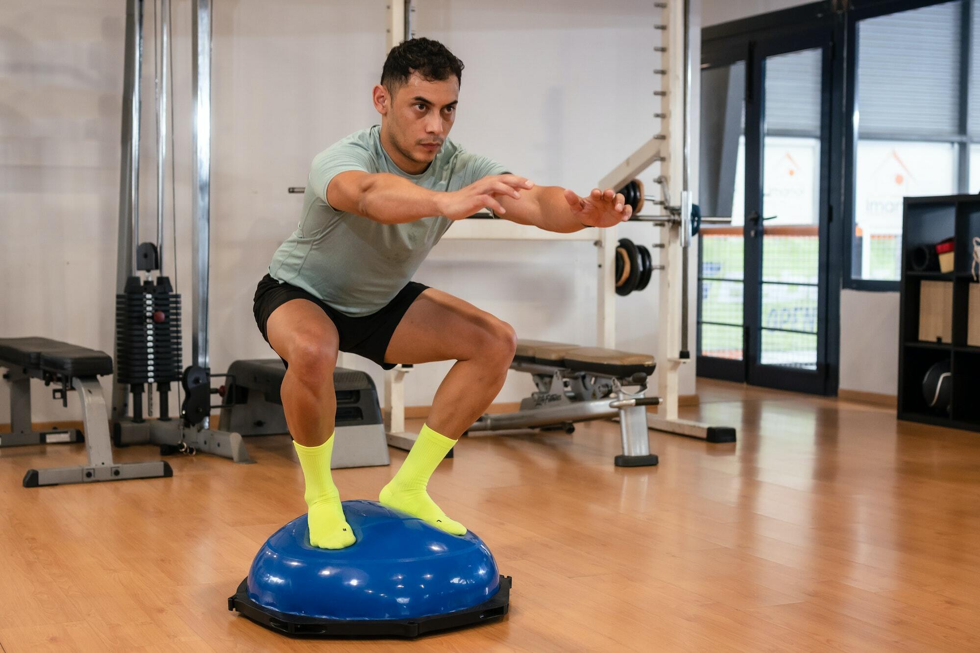 Portrait of a caucasian man in the gym doing balance exercises for the ankle